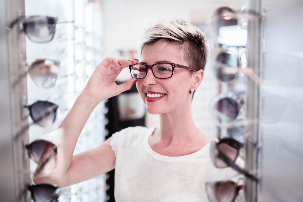 a woman trying on glasses in an optical