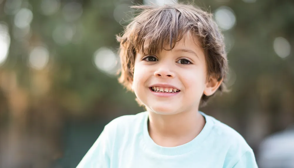a little boy smiling outside