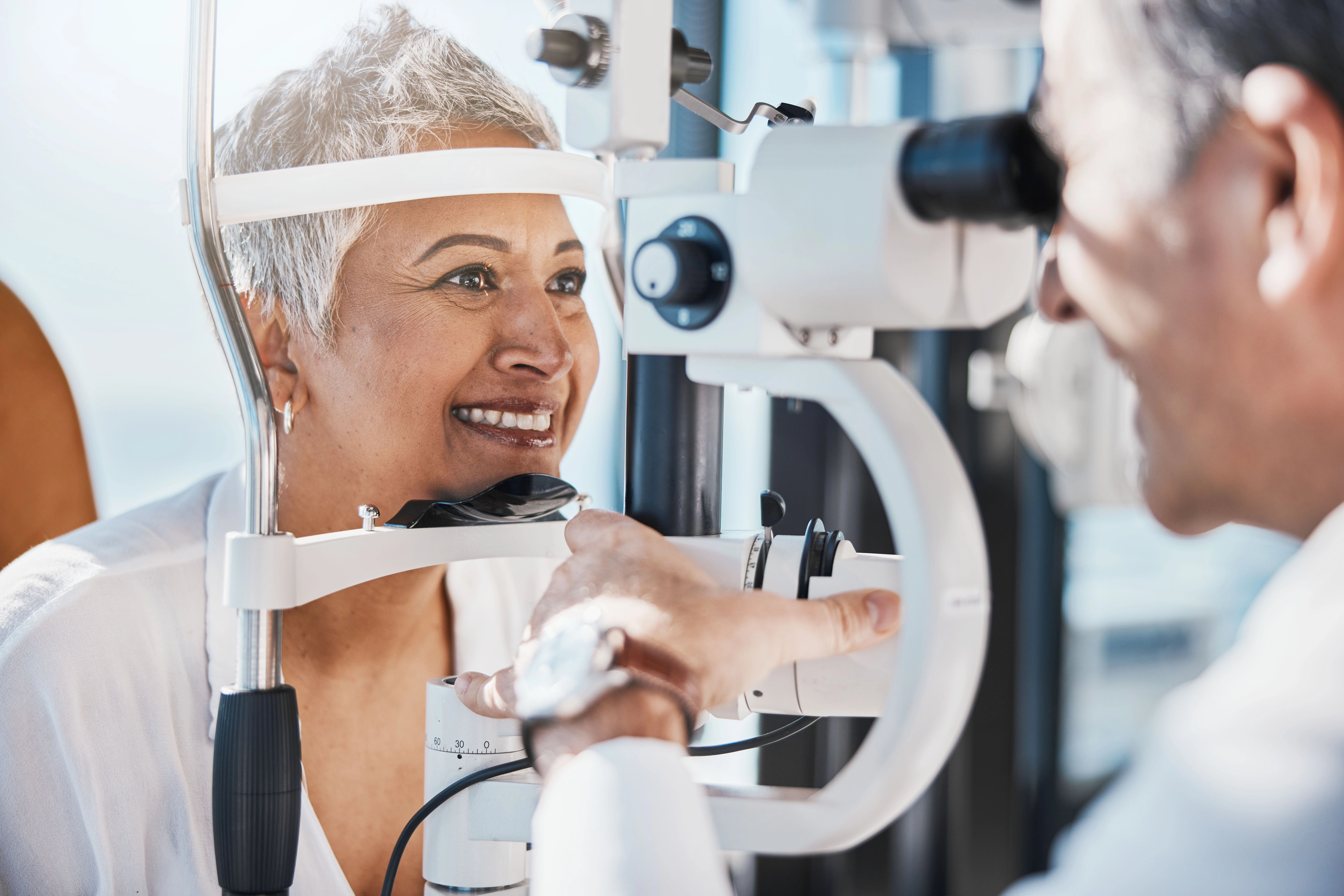 eye-care-blue-island A smiling older woman gets her eyes checked by her doctor.